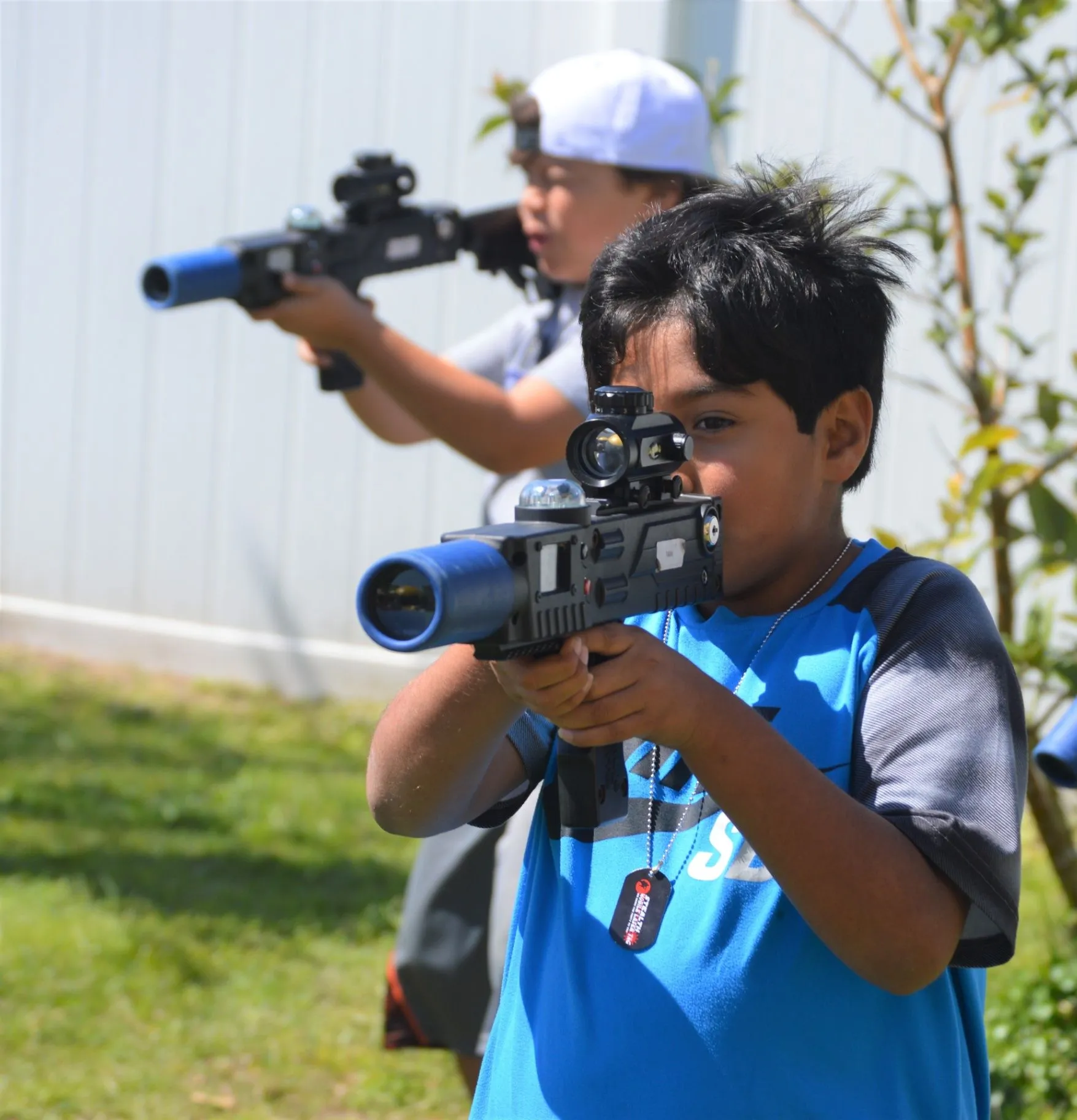 Two players using laser tag equipment outdoors